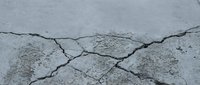 Cracked concrete surface with deep fissures and weathered texture showing structural damage and deterioration for construction and repair concepts.