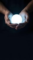 Male hands holding glowing orb against dark background, symbolizing innovation, energy, and future technology concepts for business and creative projects.