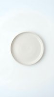 Empty white ceramic plate on clean white background isolated for kitchen and dining design projects.