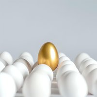 Golden egg standing out among white eggs on light background, symbolizing uniqueness, leadership and exceptional value in business concept.