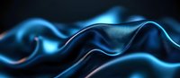 Smooth flowing blue silk fabric creates elegant waves and curves against dark background, showcasing luxurious textile movement and light reflection.