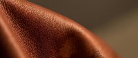 Close-up of warm bronze metallic surface with textured finish and soft lighting, suitable for backgrounds and design projects.