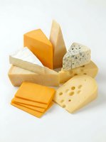 Assorted cheese varieties including cheddar, brie, blue cheese and swiss displayed on white background for food, culinary and dairy product design projects.