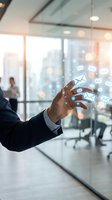 Businessman in formal suit interacting with floating email icons in modern office environment with city skyline view, representing digital communication and business messaging technology.