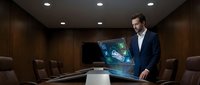 Professional businessman presenting holographic world map display in modern corporate boardroom with advanced technology interface.