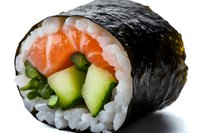Fresh sushi roll with raw salmon, cucumber and green onion wrapped in nori seaweed and white rice, close up on white background.