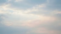 Soft pastel clouds drift across serene sky creating peaceful atmospheric background for meditation, wellness and tranquil design projects.