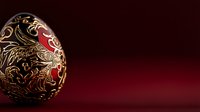 Decorative Easter egg with intricate gold floral pattern and mythical creatures on deep red background. Traditional folk art design against dark burgundy surface.