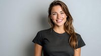 Young woman with long brown hair wearing black t-shirt smiling against gray background, perfect for lifestyle, fashion, or casual apparel marketing.