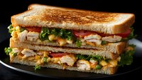 Freshly grilled club sandwich with layers of tender chicken, crispy bacon, lettuce, tomatoes, and melted cheese on toasted bread, served on black plate.