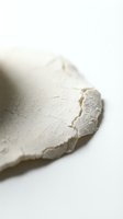 Closeup of white cream or paste texture with rough, cracked surface and torn edges on neutral background for cosmetic, skincare, or food product applications.