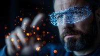 Bearded man with glowing digital particles across eyes in dark setting with orange bokeh lights, representing virtual reality and futuristic technology concepts.