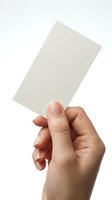 Hand holding blank white card mockup isolated on white background for business presentation and branding design projects.