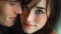 Close up portrait of young caucasian couple in love, tender romantic moment with gentle smiles and eye contact, soft natural lighting highlights freckles and blue eyes.