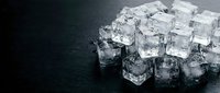 Crystal clear ice cubes scattered on dark wet surface, perfect for beverage, cocktail, and refreshment design projects.
