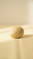 Handmade ceramic pottery bowl with speckled glaze on neutral beige background. Artisan crafted stoneware dish with organic curved form and natural texture.