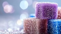 Stacked glitter-covered cubes in purple, rose gold, and blue with bokeh lights and sparkles, suitable for festive backgrounds and holiday designs.