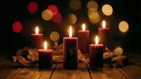 Festive candles glowing warmly with colorful bokeh lights creating cozy holiday atmosphere for seasonal celebrations and home decor.