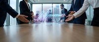 Business professionals in suits collaborating around conference table with leadership hologram display in modern office boardroom setting.