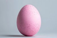 Pink speckled egg with dark spots on neutral background for Easter holiday decorations and spring seasonal designs.