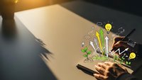 Creative business planning concept with hand drawing growth icons on notebook. Brainstorming session with lightbulb and plant symbols for startup development.