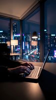 Professional working late on laptop in modern office with city skyline view through windows at night for business and technology concepts.