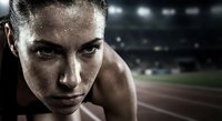 Determined female athlete with sweat drops on face looking intensely at camera in stadium lighting for sports motivation and fitness campaigns.