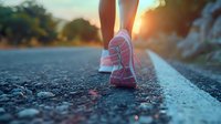 Close-up of pink running shoes on asphalt road during golden sunset, inspiring fitness and healthy lifestyle concept perfect for wellness and motivation campaigns.