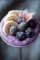 Frozen berries and banana slices on purple smoothie bowl garnished with pink flower petals, creating fresh healthy breakfast composition.
