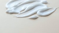 White cosmetic cream texture smears on beige background for skincare and beauty product advertising and packaging design applications.