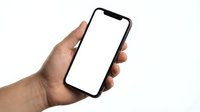 Hand holding modern smartphone with blank white screen isolated on white background for mockup and app presentation purposes.