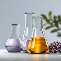 Laboratory glassware with colorful liquids in purple and amber tones, arranged with fresh grapes on light background. Clean composition for science or cosmetic concepts.