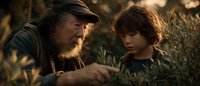 Bearded father and young son sharing intimate moment outdoors in golden sunlight among green foliage, depicting family bonding and parental guidance in nature.