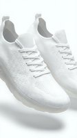 White knit sneakers with laces on a light background, showcasing breathable mesh texture and modern sole design for fashion and sport.