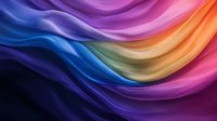 Vibrant flowing waves of colorful silk fabric create dynamic curves and folds in rainbow hues from deep purple to orange, pink and blue against dark background.