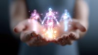 Glowing ethereal figures floating above cupped hands against dark background, representing spiritual energy, consciousness and metaphysical concepts.
