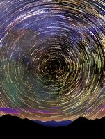 Circular star trails swirl in colorful patterns above dark mountain silhouettes, capturing long exposure night sky movement in vibrant blues, purples and yellows.