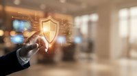Businessman hand touching digital shield icon with circuit board pattern representing cybersecurity protection and data safety in modern office environment.