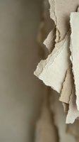 Torn beige paper pieces with rough edges creating abstract texture composition for creative design projects and artistic backgrounds.