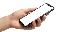 Hand holding modern smartphone with blank white screen isolated on white background for mobile app mockup and digital technology presentation.