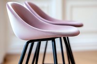 Modern pink bar stools with black metal legs against light interior background, showcasing contemporary furniture design and minimalist home decor style.