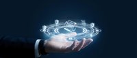 Businessman hand holding futuristic holographic house model with digital interface elements for real estate technology and smart home concepts.