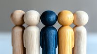 Wooden figures standing in row showing diversity and inclusion concept, leadership teamwork metaphor on light background, selective focus on blue figure.