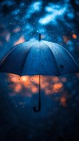 Blue umbrella with raindrops against dramatic night sky with orange and blue bokeh lights. Moody atmospheric weather photography capturing rainfall and stormy conditions.