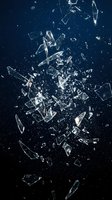 Shattered glass fragments exploding with dynamic motion against dark blue background. Broken crystal pieces scattered in dramatic destruction pattern.