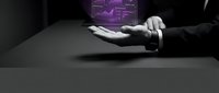 Young adult male with light skin tone wearing dark business attire, hands positioned on dark surface with glowing purple holographic interface display in background, representing technology innovation and digital transformation.