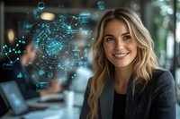 Young blonde businesswoman in black blazer smiling at camera with futuristic holographic interface displaying data analytics and business metrics in modern office.