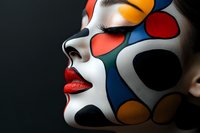 Side profile of woman with creative geometric face paint in vibrant colors against dark background showcasing artistic makeup and bold red lips for carnival or fashion.