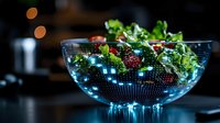 Fresh green salad with berries in illuminated glass bowl with digital holographic world map pattern glowing in dark atmospheric setting. For food tech concepts.