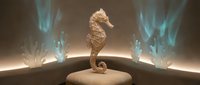 Golden seahorse sculpture on wooden surface with mystical blue flames creating magical underwater atmosphere for fantasy design projects.